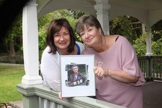 Carol and Sheila holding a picture of Peter
